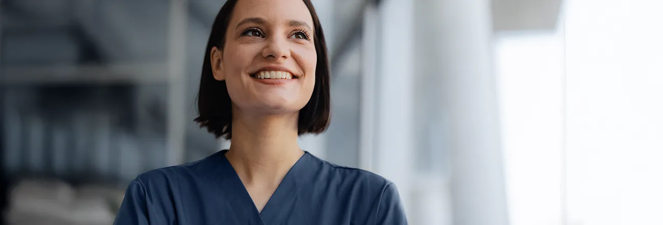 Médica de cabelo curto, sorrindo com satisfação pelo serviço personalizado de planejamento patrimonial como pessoa física.