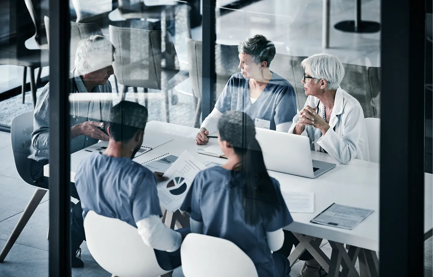 Médicos reunidos em uma mesa, conversando sobre planejamento financeiro pessoal